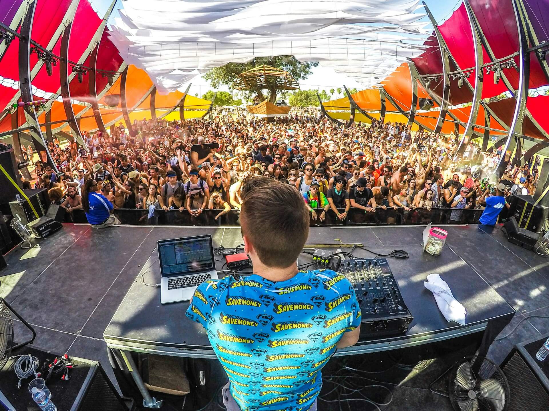 dj standing infront of a crowd playing music